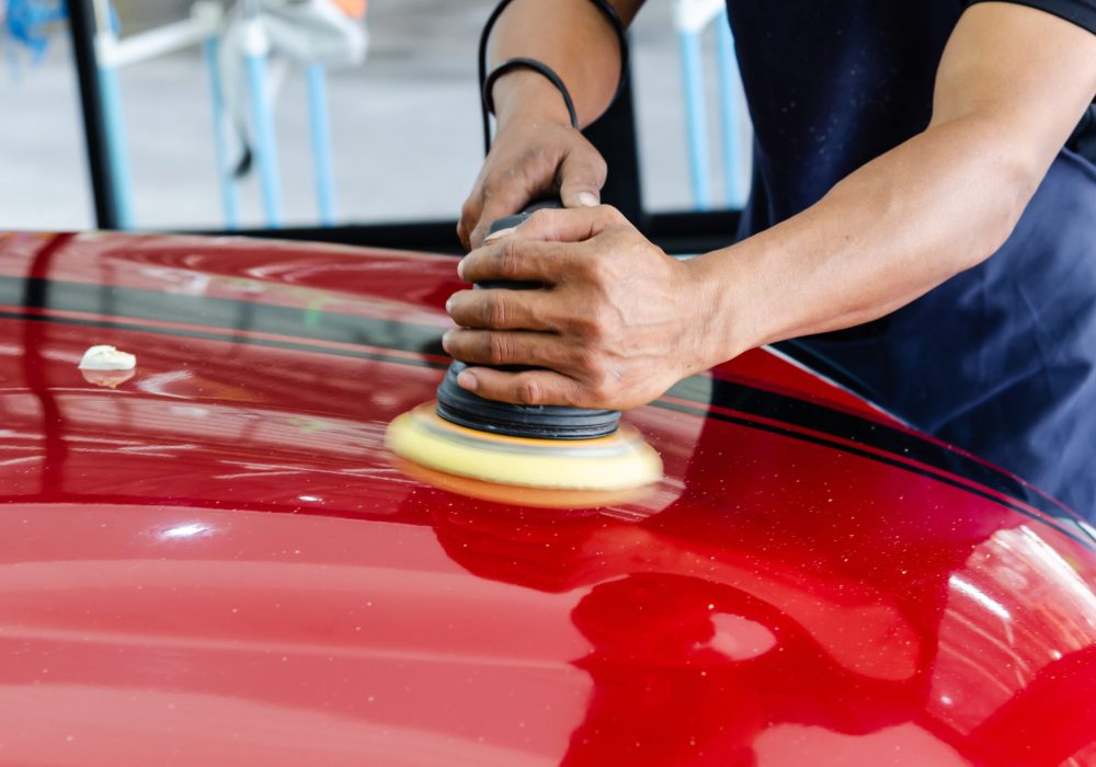 Car detailing - Car care service.
Man holding a polisher in his hand.